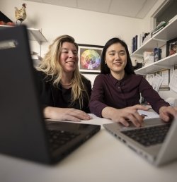 Two staff members at the Marcus Institute for Aging Research in Boston work together on laptops.
