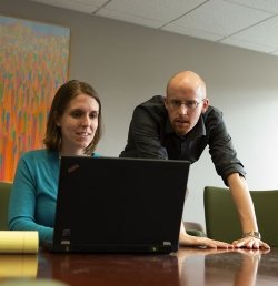 Two Marcus Institute researchers review information on a laptop computer.